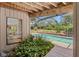Screened pool view features an outside bench, lush plants and a view to the dining room at 3133 Harvest Moon Dr, Palm Harbor, FL 34683