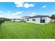 Fenced backyard with lush green grass and newly constructed home exterior at 3146 Forrest Plum Ct, Zephyrhills, FL 33540