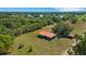 Aerial view of a charming single-story home with a metal roof, surrounded by lush greenery and mature trees on a spacious lot at 3147 Sydney Dover Rd, Dover, FL 33527