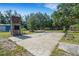 Backyard view of a brick fireplace, concrete patio, garden beds, and storage sheds at 3147 Sydney Dover Rd, Dover, FL 33527