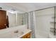 Bathroom featuring a single sink vanity and a shower-tub combination with a floral shower curtain and a storage rack at 3147 Sydney Dover Rd, Dover, FL 33527