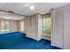 Bedroom with blue carpet, wallpaper, two windows, and closet space, offering a cozy and bright space at 3147 Sydney Dover Rd, Dover, FL 33527