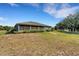 Rear exterior view of the home with a screened-in porch and well-maintained landscaping at 3147 Sydney Dover Rd, Dover, FL 33527