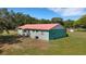 Single-story home featuring durable metal roof and painted siding with a well-manicured lawn and mature trees in the background at 3147 Sydney Dover Rd, Dover, FL 33527