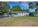 Single-story home with blue and white accents, featuring a screened-in porch, storage shed and manicured lawn at 3147 Sydney Dover Rd, Dover, FL 33527