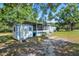 Exterior view of a single-story home featuring a screened-in porch, storage shed, and well-maintained lawn at 3147 Sydney Dover Rd, Dover, FL 33527