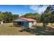 Charming single-story home featuring a metal roof and a screened-in porch, surrounded by lush landscaping and mature trees at 3147 Sydney Dover Rd, Dover, FL 33527