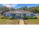 Charming blue home featuring a manicured lawn, tidy flower beds, and an inviting front porch at 3147 Sydney Dover Rd, Dover, FL 33527