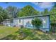Rear view of a single-story home featuring a screened-in porch, blue and white accents, and lush landscaping at 3147 Sydney Dover Rd, Dover, FL 33527
