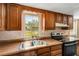 Kitchen area showcasing oak cabinets, laminate countertops, stainless steel sink, and bright natural light at 3147 Sydney Dover Rd, Dover, FL 33527
