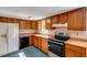 Cozy kitchen features oak cabinets, a stainless steel stove, and white refrigerator appliance at 3147 Sydney Dover Rd, Dover, FL 33527
