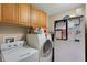 Modern laundry room featuring a front-load washer and dryer, storage cabinets and refrigerator at 3147 Sydney Dover Rd, Dover, FL 33527