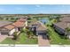 An aerial view of a single-Gathering home with a lush green lawn, terracotta roof, and serene lake backdrop at 3167 Forsythia Dr, Odessa, FL 33556