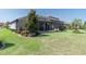 Spacious backyard featuring a screened-in pool, green grass, tasteful landscaping, and ample space to relax at 3167 Forsythia Dr, Odessa, FL 33556