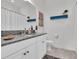 Bright bathroom with granite countertops, white cabinets, and decorative blue shelving at 3167 Forsythia Dr, Odessa, FL 33556
