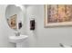 Bathroom featuring a pedestal sink, round mirror, and neutral paint at 3167 Forsythia Dr, Odessa, FL 33556