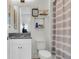 Bright bathroom featuring a white vanity, toilet, and a striped shower curtain at 3167 Forsythia Dr, Odessa, FL 33556