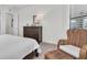 Bedroom with a large bed, wicker chair, dresser, neutral tones, and white trim at 3167 Forsythia Dr, Odessa, FL 33556
