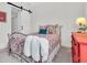 Bedroom with metal bed frame, red dresser, barn door, and decorative pillows at 3167 Forsythia Dr, Odessa, FL 33556