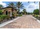 Gated community entrance with a guard house, brick-paved road, and beautiful landscaping at 3167 Forsythia Dr, Odessa, FL 33556