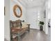 Cozy entryway features a rustic bench, decorative mirror, and bright natural light at 3167 Forsythia Dr, Odessa, FL 33556