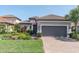 Charming single Gathering home features a two-car garage, tile roof, and a beautifully landscaped front yard at 3167 Forsythia Dr, Odessa, FL 33556