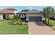 Charming home with a paved driveway, two-car garage, and beautiful landscaping with an American flag at 3167 Forsythia Dr, Odessa, FL 33556
