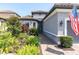 A beautifully landscaped front of a home with a brick walkway leading to the front door at 3167 Forsythia Dr, Odessa, FL 33556