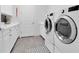 Well-lit laundry room featuring modern washer and dryer with grey wood flooring and stylish rug at 3167 Forsythia Dr, Odessa, FL 33556