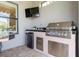 Built-in outdoor kitchen equipped with stainless steel grill, fridge, and sink for outdoor entertaining at 3167 Forsythia Dr, Odessa, FL 33556