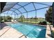 Screened pool area with in-ground pool, waterfall feature, and lake views at 3167 Forsythia Dr, Odessa, FL 33556