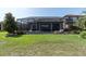 Backyard featuring a screened-in pool, perfect for relaxation and entertaining with green grass and blue sky at 3167 Forsythia Dr, Odessa, FL 33556
