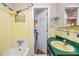 Retro bathroom featuring a yellow sink, tiled walls, a shower, and a bathtub at 3320 Jackson N St, St Petersburg, FL 33704