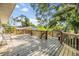Wide-angle of the wood deck showing the wood-railings, steps to the yard and tropical surroundings at 3320 Jackson N St, St Petersburg, FL 33704