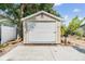 Garage featuring a functional roll-up door, mailbox, and convenient paved parking area at 3320 Jackson N St, St Petersburg, FL 33704