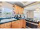 This is a kitchen that features wooden cabinets, countertops, a stainless-steel stove, and a kitchen sink at 3320 Jackson N St, St Petersburg, FL 33704