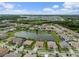 Aerial view of a residential community with houses surrounding a beautiful serene lake at 33219 Kateland Dr, Wesley Chapel, FL 33545