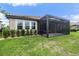 Exterior of home showing screened in porch and well manicured yard at 33219 Kateland Dr, Wesley Chapel, FL 33545