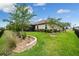 Well-maintained backyard with manicured landscaping, a screened lanai, and a fenced perimeter for privacy at 33219 Kateland Dr, Wesley Chapel, FL 33545