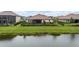 Wide backyard view overlooking a pond, showcasing a screened lanai and manicured lawn space at 33219 Kateland Dr, Wesley Chapel, FL 33545