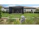 Beautiful backyard featuring a screened lanai, stone water feature, lush lawn, and well-maintained landscaping at 33219 Kateland Dr, Wesley Chapel, FL 33545