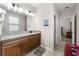 Bathroom featuring a granite vanity with and sinks and views of the bedroom through the door at 33219 Kateland Dr, Wesley Chapel, FL 33545