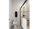 Bathroom showcasing a toilet, towel rack, and glass-enclosed shower with a handheld shower head at 33219 Kateland Dr, Wesley Chapel, FL 33545