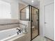 Bathroom showcasing a soaking tub, walk-in shower with black frame, and tile flooring at 33219 Kateland Dr, Wesley Chapel, FL 33545