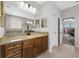 Bathroom featuring a granite vanity with and sinks and views of the bedroom through the door at 33219 Kateland Dr, Wesley Chapel, FL 33545