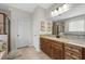 Bathroom featuring a granite countertop vanity, mirror, tan tile flooring, and shower with glass door at 33219 Kateland Dr, Wesley Chapel, FL 33545