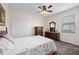 Cozy bedroom featuring closet, ceiling fan, carpet, dresser with lamps, and a window at 33219 Kateland Dr, Wesley Chapel, FL 33545
