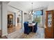 This dining room features a large window, wood floors, and a table with elegant blue upholstered chairs at 33219 Kateland Dr, Wesley Chapel, FL 33545