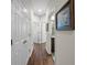 Hallway featuring wood floors, white walls, and several closed doors at 33219 Kateland Dr, Wesley Chapel, FL 33545