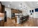 A spacious kitchen features wood floors, brown cabinetry, and an island with granite counters and barstool seating at 33219 Kateland Dr, Wesley Chapel, FL 33545